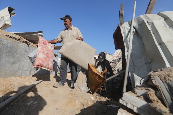 فلسطينيون نازحون يتفقدون الأضرار التي لحقت بخيامهم ومنازلهم وممتلكاتهم في موقع غارة إسرائيلية استهدفت منزل عائلة العسلي في بيت لاهيا، شمال قطاع غزة، في 30 يونيو/حزيران 2026. تصوير: بلال أسامة
