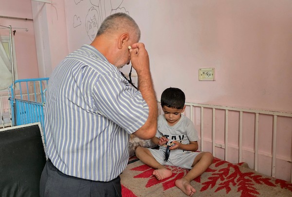 الفلسطينية إيمان أبو جامع تجلس إلى جانب طفلها ياسر عرفات، البالغ ست سنوات، أثناء تلقيه العلاج من سوء التغذية في مجمع ناصر الطبي بخان يونس، جنوب قطاع غزة، في 8 يوليو/تموز 2026. وتقول الأم إنها فقدت زوجها وابنًا آخر بسبب مضاعفات سوء التغذية. تصوير: طارق محمد