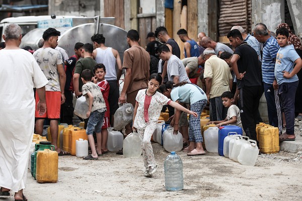 نازحون فلسطينيون يتجمعون للحصول على المياه من شاحنة توزيع في مخيم البريج وسط قطاع غزة، 8 يوليو/تموز 2026، مع تفاقم أزمة المياه إثر توقف عدد من محطات التحلية بسبب نقص الوقود. تصوير: معز صالحي