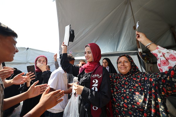 الطالبة دانا سعادة تحتفل مع عائلتها داخل خيمة للنازحين غرب مدينة غزة، بعد حصولها على معدل 96% في الفرع الأدبي بامتحانات التوجيهي، 24 تموز/ يوليو 2026. تصوير: بلال أسامة