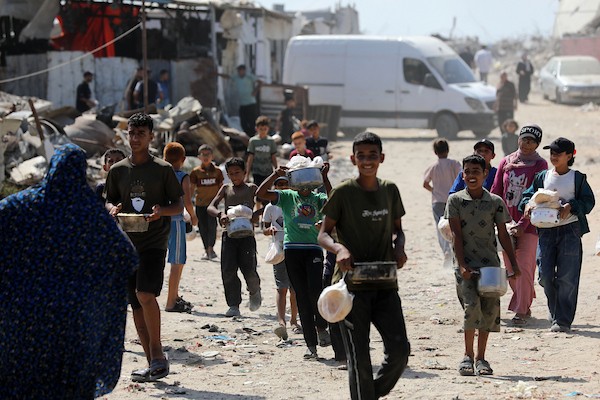 في الثاني من يوليو/تموز 2026، تجمع فلسطينيون نازحون، بينهم نساء وأطفال، لتلقي وجبات طعام من مركز توزيع خيري شرق مدينة غزة. (صورة: بلال أسامة)