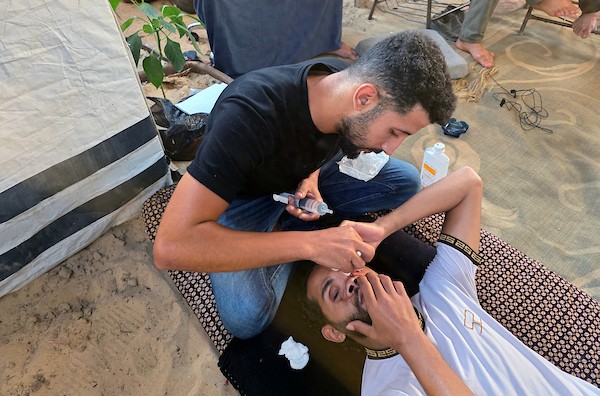 الشقيقان محمد دبور وموسى دبور داخل خيمة للنازحين في خان يونس، جنوب قطاع غزة، في 9 يوليو/تموز 2026. فقد محمد بصره بالكامل، فيما فقد موسى عينه اليسرى، إثر حادثة قرب مركز لتوزيع المساعدات في يوليو/تموز 2025 أودت بحياة شقيقهما حسين.(تصوير: طارق محمد)
