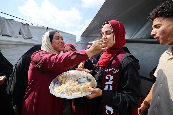 الطالبة دانا سعادة تحتفل مع عائلتها داخل خيمة للنازحين غرب مدينة غزة، بعد حصولها على معدل 96% في الفرع الأدبي بامتحانات التوجيهي، 24 تموز/ يوليو 2026. تصوير: بلال أسامة