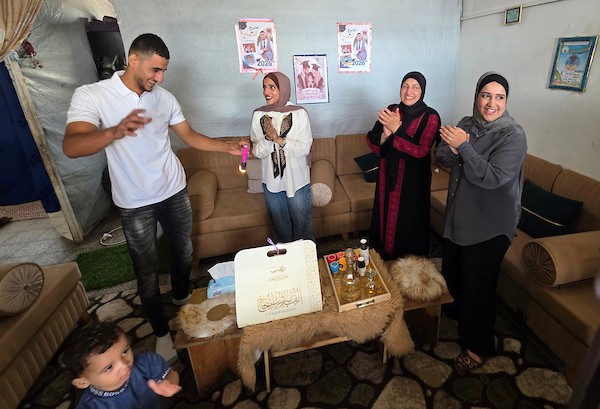 احتفل طلاب فلسطينيون وعائلاتهم بإعلان نتائج امتحانات التوجيهي (الثانوية العامة) وسط الخيام والملاجئ الجماعية والمنازل المتضررة في خان يونس، جنوب قطاع غزة، في 24 يوليو/تموز 2026. (صورة: طارق محمد)