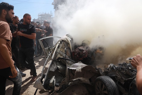 فلسطينيون يتجمعون في موقع غارة إسرائيلية استهدفت مركبة غرب مدينة غزة، في 9 يوليو/تموز 2026. وبحسب مصادر محلية، أسفر القصف عن استشهاد شخص وإصابة آخرين. (تصوير: هادي داود)