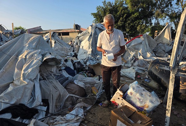 عائلات فلسطينية نازحة تتفقد الأضرار التي لحقت بخيامها وممتلكاتها بعد غارة إسرائيلية استهدفت مخيمًا للنازحين في منطقة المواصي بخان يونس، جنوب قطاع غزة، في 30 يونيو/حزيران 2026. تصوير: طارق محمد