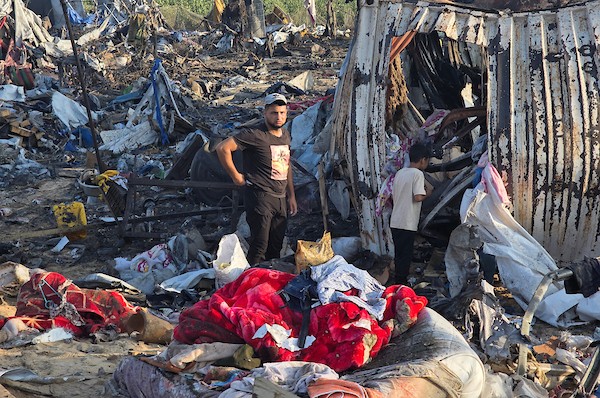 عائلات فلسطينية نازحة تتفقد الأضرار التي لحقت بخيامها وممتلكاتها بعد غارة إسرائيلية استهدفت مخيمًا للنازحين في منطقة المواصي بخان يونس، جنوب قطاع غزة، في 30 يونيو/حزيران 2026. تصوير: طارق محمد