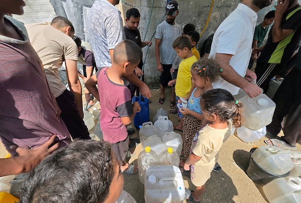 فلسطينيون، بينهم نساء وأطفال، يملؤون حاويات بمياه محلاة في محطة تحلية مياه بخان يونس، جنوب قطاع غزة، في 23 أغسطس/آب 2026.(صورة: طارق محمد)