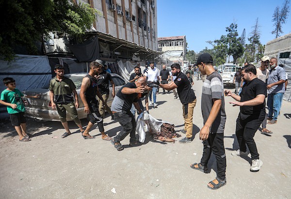 انتشل مسعفون ومتطوعون جثامين شهداء وجرحى من موقع غارة إسرائيلية استهدفت مقرًا للشرطة البلدية وسط غزة، 19 أغسطس/آب 2026،(صورة: بلال أسامة)