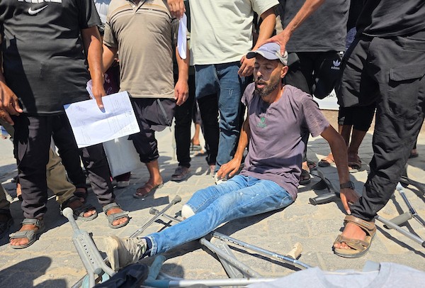 مرضى وجرحى فلسطينيون يحملون تحويلات طبية في احتجاج أمام مجمع ناصر الطبي في خان يونس، جنوب قطاع غزة، في 23 أغسطس/آب 2026، (صورة: طارق محمد)