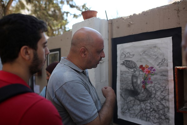 حضر فلسطينيون معرض ريشة السلام الذي ضمّ أعمالاً فنية ورسومات لشابات من مدينة غزة، وذلك في 30 أغسطس/آب 2026. تصوير: محمد صالحة