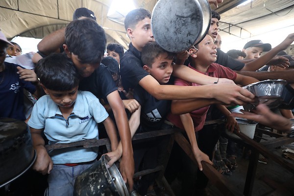 نازحون فلسطينيون يتجمعون لتلقي وجبات طعام من مطبخ خيري في مخيم النصيرات للاجئين، وسط قطاع غزة، في 16 آب/أغسطس 2026. (صورة: حسن الجدي)