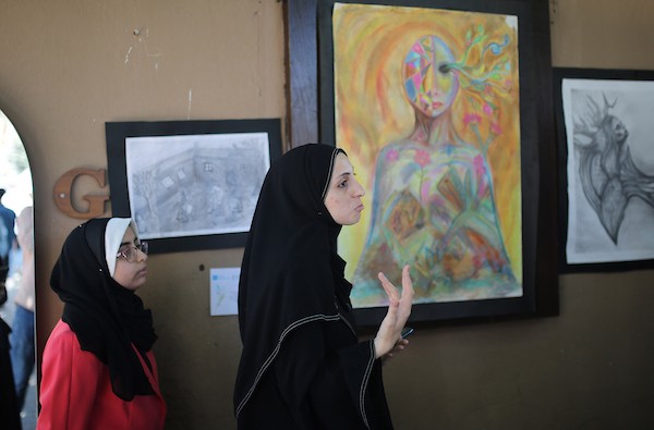 حضر فلسطينيون معرض ريشة السلام الذي ضمّ أعمالاً فنية ورسومات لشابات من مدينة غزة، وذلك في 30 أغسطس/آب 2026. تصوير: محمد صالحة