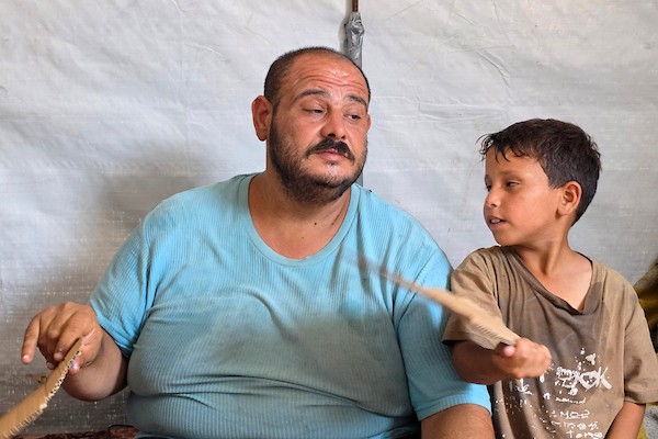 في خيمة بسيطة بمخيم للنازحين في منطقة المواصي بخان يونس، تحاول عائلة محمد المغير مواصلة تفاصيل حياتها اليومية وسط موجة حر ونقص في الاحتياجات (تصوير: طارق محمد)