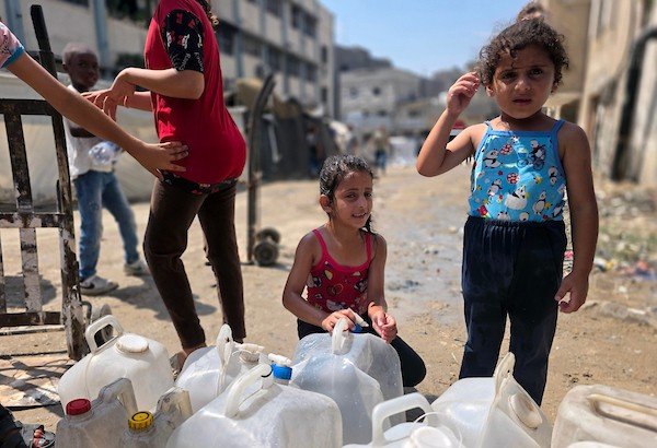 فلسطينيون، بينهم نساء وأطفال، يملؤون حاويات بمياه محلاة في محطة تحلية مياه بخان يونس، جنوب قطاع غزة، في 23 أغسطس/آب 2026.(صورة: طارق محمد)