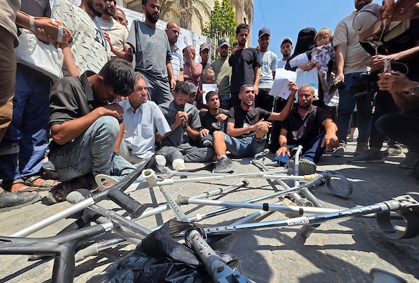 مرضى وجرحى فلسطينيون يشاركون في وقفة أمام مجمع ناصر الطبي في خان يونس، جنوب قطاع غزة، في 9 أغسطس/آب 2026، مطالبين بفتح المعابر والسماح لهم بمغادرة القطاع لاستكمال العلاج، في ظل تراجع أعداد المسافرين وتراكم طلبات الإحالة الطبية. (تصوير: طارق محمد)