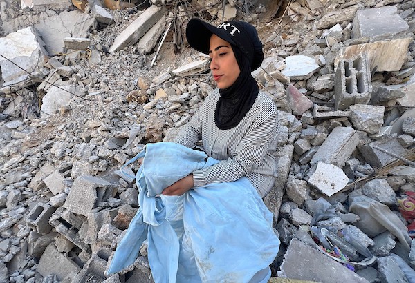 العروس الفلسطينية آية مطران تجلس على أنقاض منزلها المستقبلي في مخيم المغازي، وسط قطاع غزة، في 6 أغسطس/آب 2026، بعدما قالت إنه دُمّر في غارة جوية إسرائيلية قبل ساعات من موعد زفافها، ما أدى إلى فقدان مقتنياتها وتأجيل الحفل. تصوير: يوسف أبو وطفة
