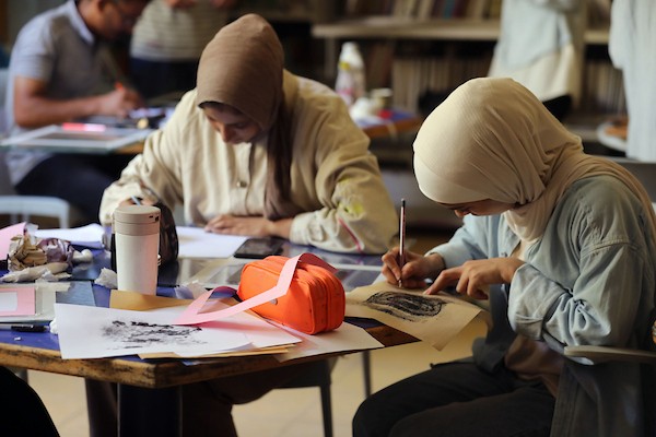 فنانون فلسطينيون خلال ورشة «الزمان والمكان» في مدينة غزة، حيث جسدت أعمالهم واقع الحرب والنزوح ورسائل الأمل والصمود، 15 أغسطس/آب 2026. تصوير: بلال أسامة.