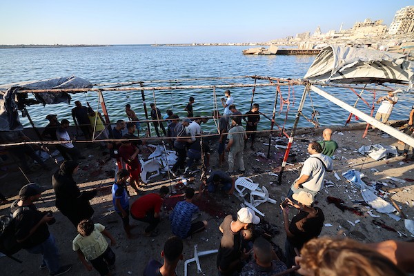 فلسطينيون في موقع غارة جوية إسرائيلية استهدفت مجموعة من المدنيين على الواجهة البحرية غرب مدينة غزة، في 18 أغسطس/آب 2026.(صورة: هادي داود)