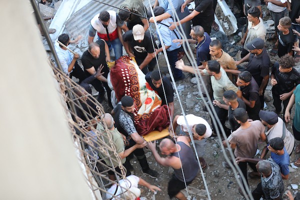 فلسطينيون يتجمعون في موقع غارة إسرائيلية استهدفت منزلاً في مخيم البريج للاجئين وسط قطاع غزة، بينما يتصاعد الدخان من المكان، في 24 أغسطس/آب 2026. الصورة: حسن الجدي