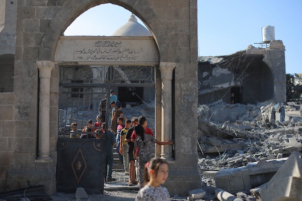يتفقد فلسطينيون الدمار الذي لحق بمسجد أبو سليم التاريخي في دير البلح، وسط قطاع غزة، في 25 أغسطس/آب 2026، بعد استهدافه في غارة إسرائيلية. (صورة: حسن الجدي)