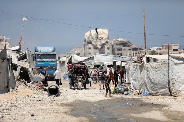 فلسطينيون نازحون يمارسون تفاصيل حياتهم اليومية بين خيام الإيواء والمباني المدمرة في شمال مدينة غزة، في 27 آب/أغسطس 2026. (تصوير: بلال أسامة)