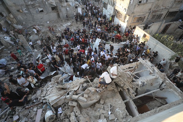 فلسطينيون يتجمعون في موقع غارة إسرائيلية استهدفت منزلاً في مخيم البريج للاجئين وسط قطاع غزة، بينما يتصاعد الدخان من المكان، في 24 أغسطس/آب 2026. الصورة: حسن الجدي