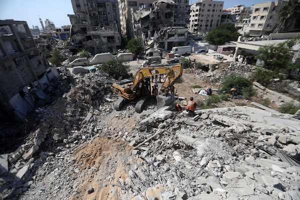 عناصر من الدفاع المدني الفلسطيني، بالتعاون مع اللجنة الدولية للصليب الأحمر، يعملون بإمكانيات محدودة لانتشال جثث من تحت أنقاض منزل عائلة غربية غرب مدينة غزة، في 11 أغسطس/آب 2026. (صورة: بلال أسامة)