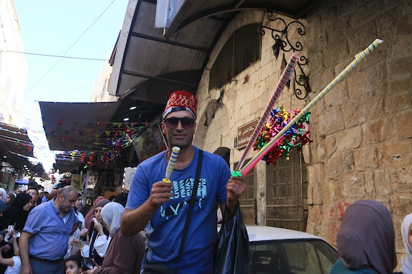 فلسطينيون بالزي التقليدي يؤدون أناشيد ومدائح دينية ويوزعون الحلوى في السوق المركزي بالبلدة القديمة في نابلس،خلال إحياء ذكرى المولد النبوي الشريف، في 25 أغسطس/آب 2026. (تصوير: محمد ناصر)