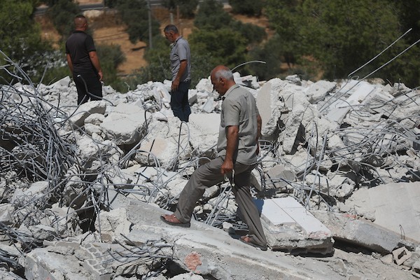 يتفقد فلسطينيون أنقاض منزل قيد الإنشاء هدمته القوات الإسرائيلية في قرية كرمة، جنوب مدينة دورا بالضفة، في 27 أغسطس/آب 2026.(صورة: مأمون وزواز)