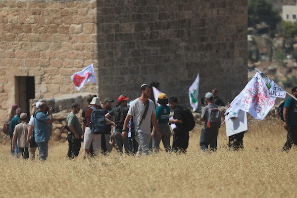 فلسطينيون ونشطاء دوليون خلال وقفة تضامنية مع أصحاب أراضٍ مهددة بالمصادرة في منطقة هراسا بمدينة بيت ساحور، في 14 أغسطس/آب 2026.(تصوير: مأمون وزواز)