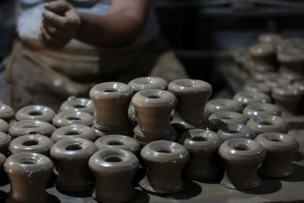 عمال فلسطينيون يصنعون الفخار يدويًا داخل مصنع متضرر في منطقة النفاق بمدينة غزة، في 6 أغسطس/آب 2026، محافظين على حرفة توارثوها عبر الأجيال رغم الدمار ونقص الموارد والمعدات. تصوير: بلال أسامة