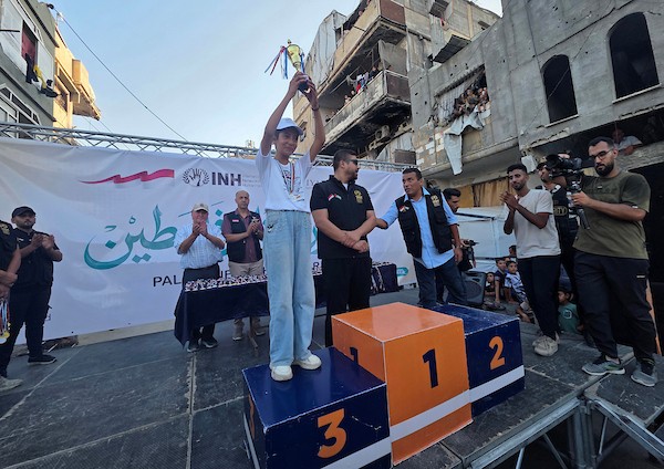 أطفال فلسطينيون يشاركون في ماراثون بين أنقاض حي الأمل في خان يونس، بالتزامن مع إطلاق مبادرة محلية لدعم الأيتام، جنوب قطاع غزة، 31 يوليو/تموز 2026. تصوير: طارق محمد.