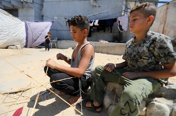 أطفال فلسطينيون يصنعون ويطيرون الطائرات الورقية في مدينة غزة في 25 أغسطس/آب 2026.(صورة: بلال أسامة)
