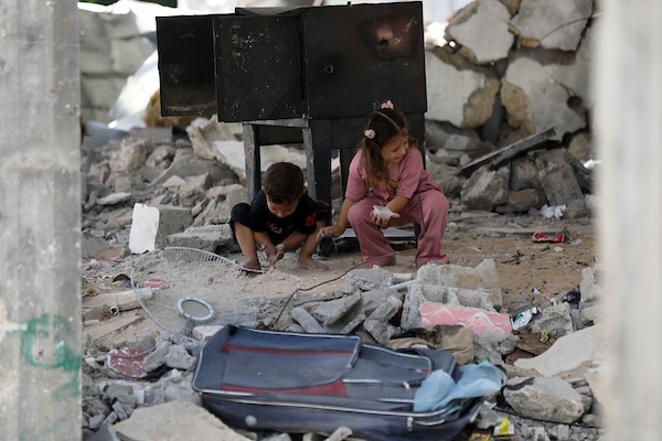 فلسطينيون يسيرون بين أنقاض المباني المدمرة في مخيم جباليا شمال قطاع غزة. تصوير: بلال أسامة