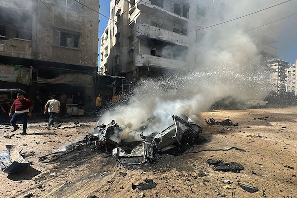 تجمّع فلسطينيون في موقع غارة إسرائيلية استهدفت مركبة مدنية في حي تل الهوى بمدينة غزة في 31 أغسطس/آب 2026، بينما يحاول رجال الإطفاء إخماد حريق اندلع في الموقع. وانتشلت فرق الإسعاف جثث ثلاثة فلسطينيين استشهدوا في الغارة. (صورة: هادي داود)