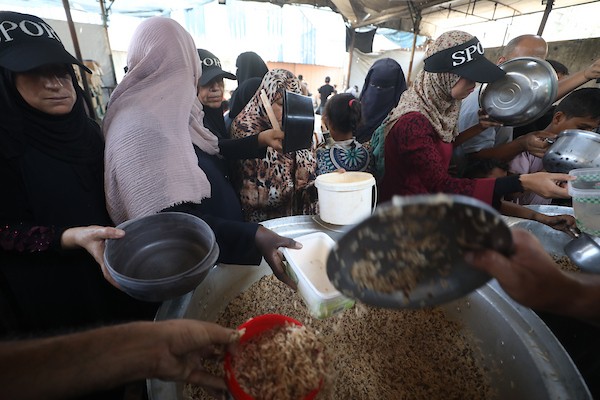 نازحون فلسطينيون يتجمعون لتلقي وجبات طعام من مطبخ خيري في مخيم النصيرات للاجئين، وسط قطاع غزة، في 16 آب/أغسطس 2026. (صورة: حسن الجدي)