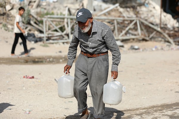 نازحون فلسطينيون ينتظرون الحصول على المياه قرب