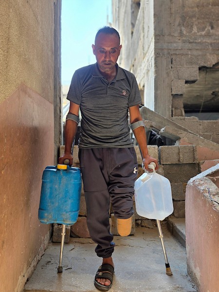 الفلسطيني محمد حسن البرغوث، الذي فقد ساقه خلال الحرب، يقف متكئًا على عكاز في خان يونس، جنوب قطاع غزة، في 12 أغسطس/آب 2026. (صورة: طارق محمد)