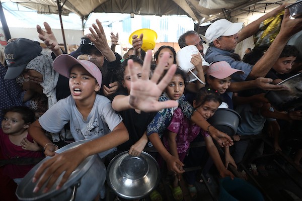 نازحون فلسطينيون يتجمعون لتلقي وجبات طعام من مطبخ خيري في مخيم النصيرات للاجئين، وسط قطاع غزة، في 16 آب/أغسطس 2026. (صورة: حسن الجدي)