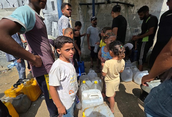 فلسطينيون، بينهم نساء وأطفال، يملؤون حاويات بمياه محلاة في محطة تحلية مياه بخان يونس، جنوب قطاع غزة، في 23 أغسطس/آب 2026.(صورة: طارق محمد)