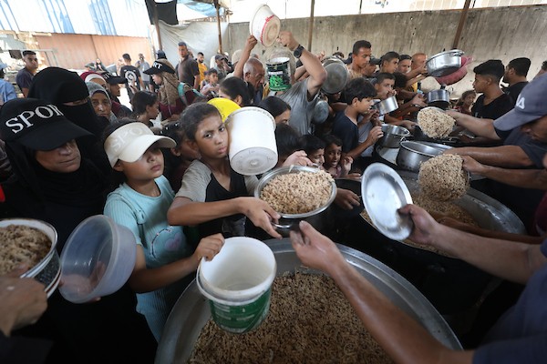 نازحون فلسطينيون يتجمعون لتلقي وجبات طعام من مطبخ خيري في مخيم النصيرات للاجئين، وسط قطاع غزة، في 16 آب/أغسطس 2026. (صورة: حسن الجدي)