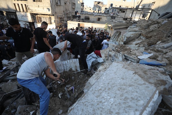 فلسطينيون يتجمعون في موقع غارة إسرائيلية استهدفت منزلاً في مخيم البريج للاجئين وسط قطاع غزة، بينما يتصاعد الدخان من المكان، في 24 أغسطس/آب 2026. الصورة: حسن الجدي