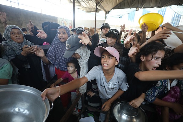 نازحون فلسطينيون يتجمعون لتلقي وجبات طعام من مطبخ خيري في مخيم النصيرات للاجئين، وسط قطاع غزة، في 16 آب/أغسطس 2026. (صورة: حسن الجدي)