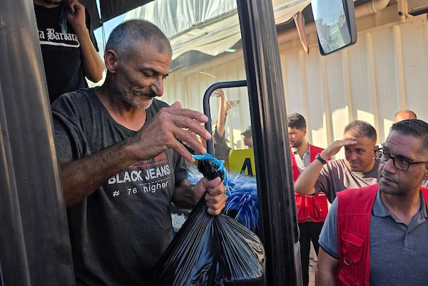 أسرى ومعتقلون فلسطينيون مفرج عنهم يصلون على متن حافلات تابعة للجنة الدولية للصليب الأحمر إلى مجمع ناصر الطبي في خان يونس، جنوب قطاع غزة، بعد نقلهم من معبر كرم أبو سالم، وسط تجمع أفراد من عائلاتهم لاستقبالهم.(تصوير: طارق محمد)