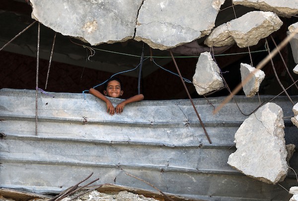 فلسطينيون يسيرون بين أنقاض المباني المدمرة في مخيم جباليا شمال قطاع غزة. تصوير: بلال أسامة