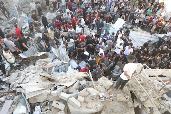 فلسطينيون يتجمعون في موقع غارة إسرائيلية استهدفت منزلاً في مخيم البريج للاجئين وسط قطاع غزة، بينما يتصاعد الدخان من المكان، في 24 أغسطس/آب 2026. الصورة: حسن الجدي