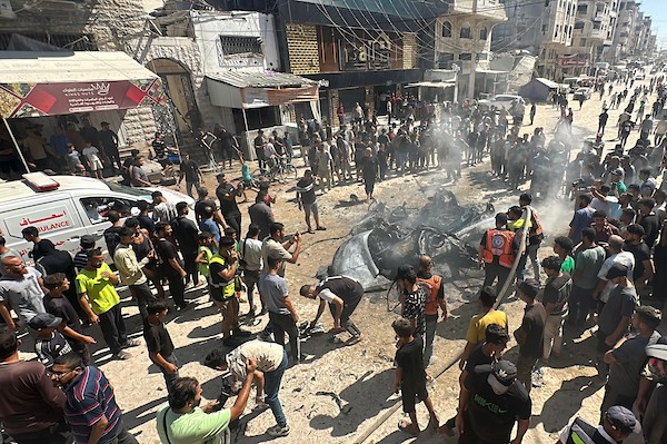 تجمّع فلسطينيون في موقع غارة إسرائيلية استهدفت مركبة مدنية في حي تل الهوى بمدينة غزة في 31 أغسطس/آب 2026، بينما يحاول رجال الإطفاء إخماد حريق اندلع في الموقع. وانتشلت فرق الإسعاف جثث ثلاثة فلسطينيين استشهدوا في الغارة. (صورة: هادي داود)