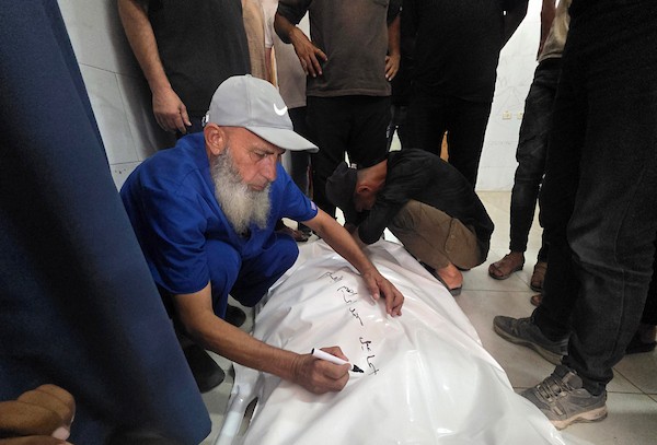 مسعفون فلسطينيون ينقلون جثمان إسماعيل محمد البريم وجرحى، بينهم أطفال، إلى مجمع ناصر الطبي بعد غارة إسرائيلية استهدفت خيمة في مخيم الغيث بمنطقة المواصي في خان يونس، 26 أغسطس/آب 2026. تصوير: طارق محمد.