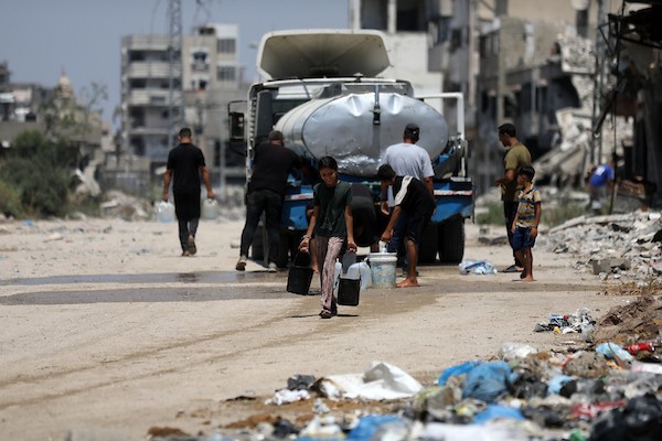 أطفال فلسطينيون نازحون يرتشفون الماء قرب مخيمات النزوح بجوار حي الشجاعية، شرق مدينة غزة، في 9 أغسطس/آب 2026، وسط ارتفاع درجات الحرارة وظروف معيشية صعبة في الخيام ومحدودية وسائل التبريد والخدمات الأساسية. (تصوير: بلال أسامة)